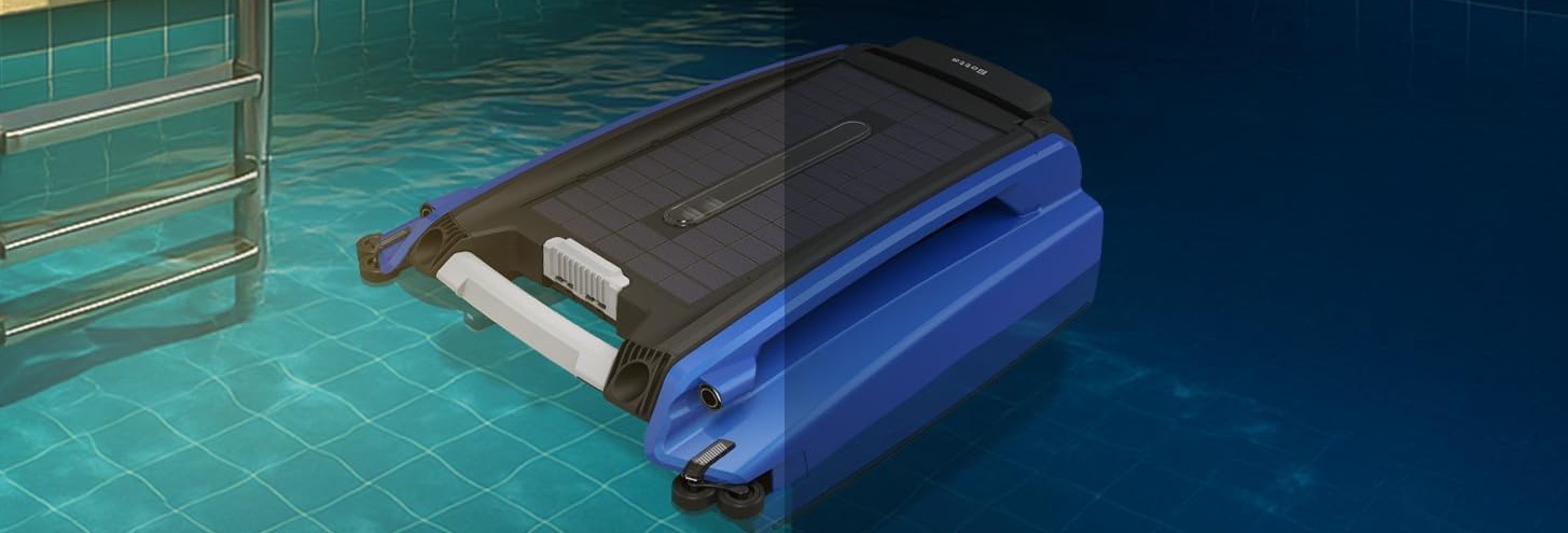 Side-angle view of the Betta SE floating in a pool near the ladder, showing the solar panel top and white handle.